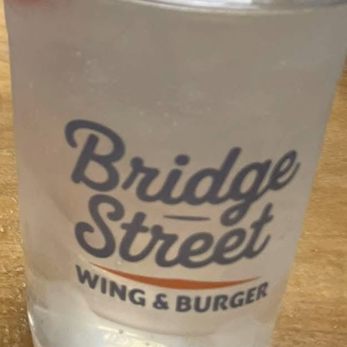 The same printed cup poured as a cocktail with lime and a cherry.